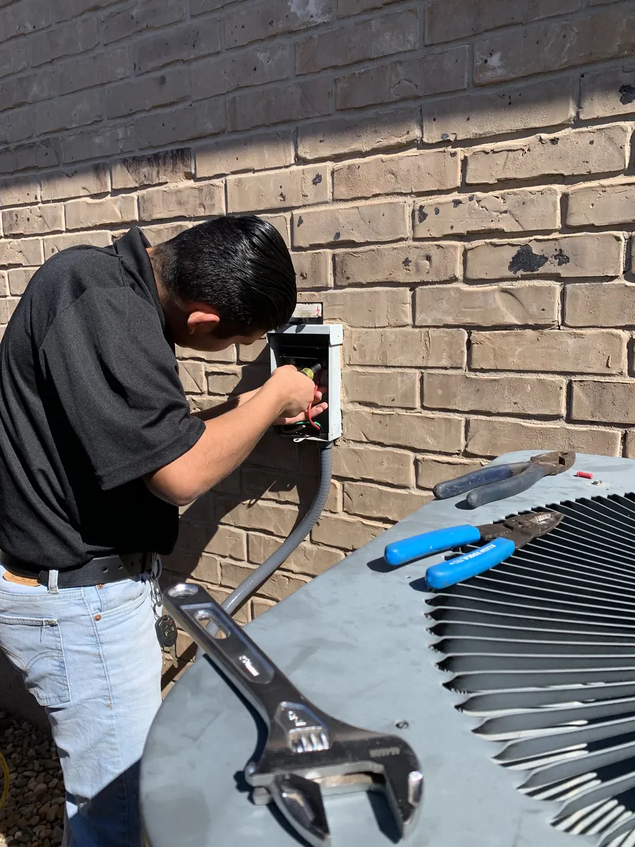 Serrato Heat and Air technician servicing an outdoor air conditioning unit in Oklahoma City