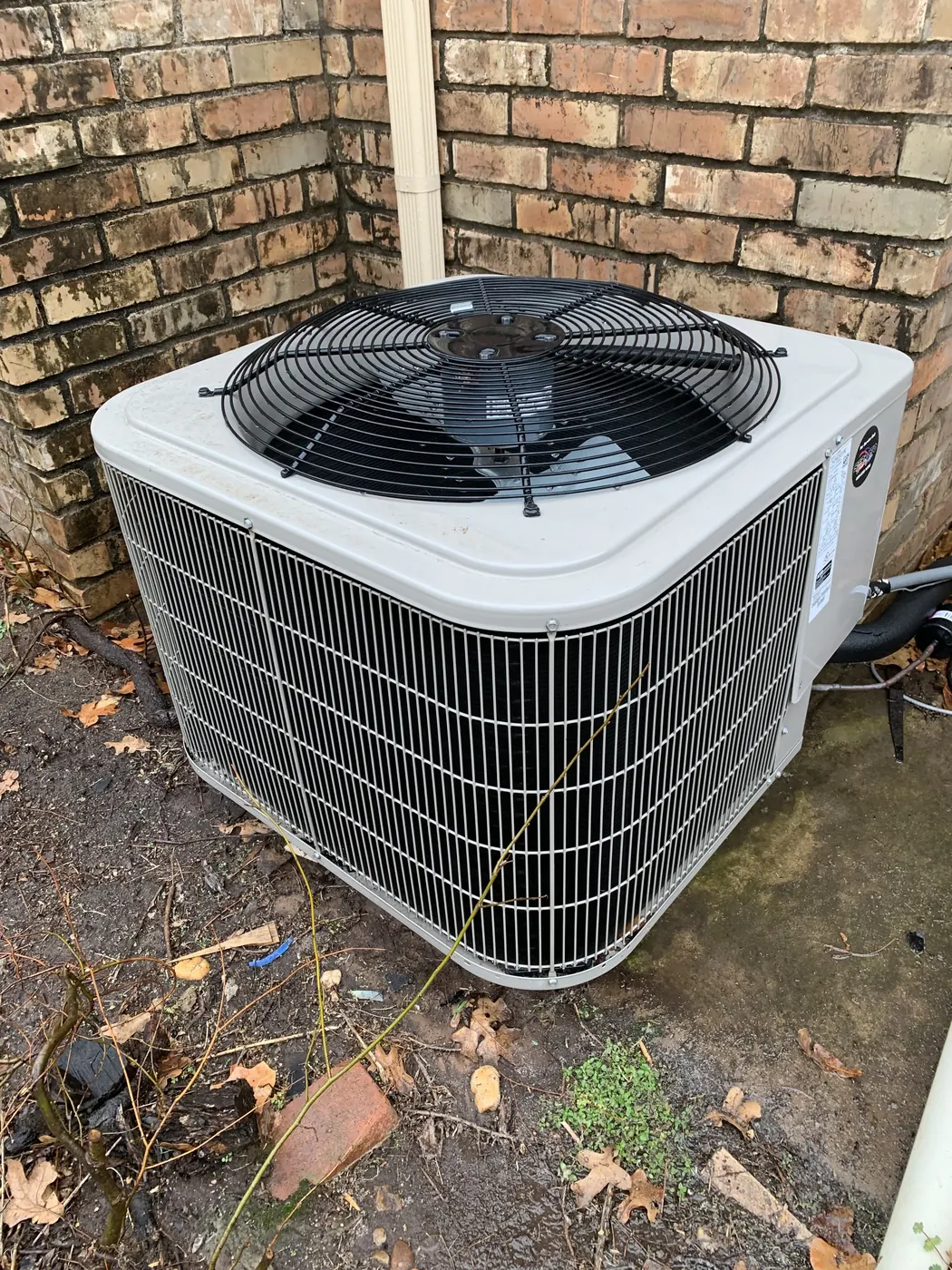 A newly installed outdoor air conditioning condenser beside an Oklahoma City brick home